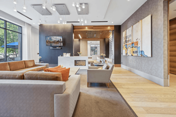 A modern living room with a grey sofa and a wooden floor.